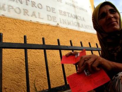 Una refugiada siria muestra su tarjeta de refugiada a las puertas del CETI de Melilla.