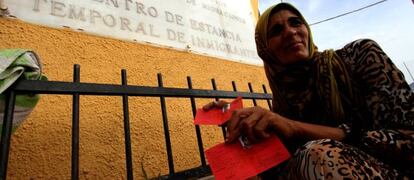 Una refugiada siria muestra su tarjeta de refugiada a las puertas del CETI de Melilla.