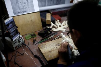 Un hombre en un taller de Pekín (China) elabora una talla sobre una pieza de marfil.