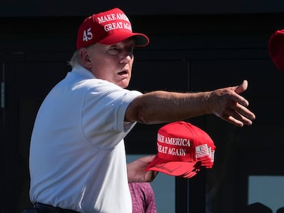 El expresidente Donald Trump lanza gorras con su autógrafo a sus seguidores, en una imagen del pasado domingo en Bedminster, Nueva Jersey.