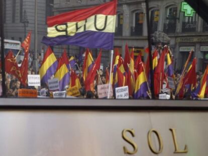 Varias personas portan banderas republicanas, en la Puerta del Sol de Madrid, tras conocerse la abdicaci&oacute;n del Rey.