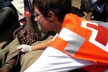 Un inmigrante exhausto recibe atención médica en la playa de las Galletas, en Tenerife, el sábado. Ese día llegaron 324 personas a Canarias.