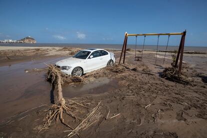 Una vehículo permanece encallado en la playa de Águilas (Murcia) tras la gota fría de este jueves.