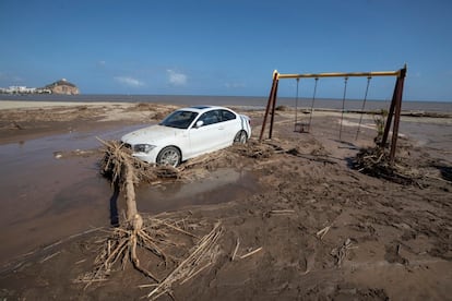 Una vehículo permanece encallado en la playa de Águilas (Murcia) tras la gota fría de este jueves.