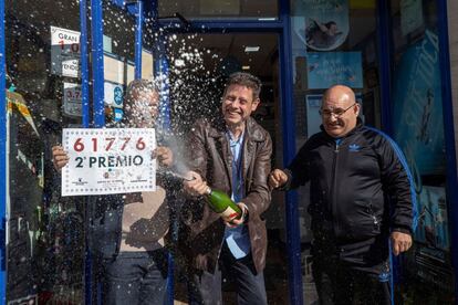 El gerente de la administración de lotería nº 2 de Fortuna José Luis Lozano, en el centro, acompañado de dos amigos celebran con cava la venta de un décimo del segundo premio del sorteo del niño del número 61776, vendido en Fortuna (Murcia).