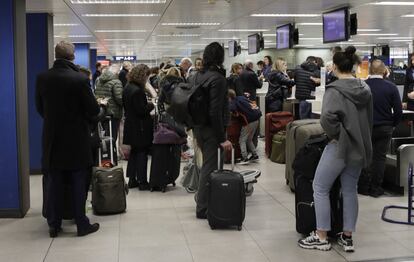 Las fuerzas del orden de los condados de Surrey y Sussex prosiguen hoy la búsqueda del piloto o pilotos que operan estos vehículos a fin de impedir que sigan en el aire. En la imagen, pasajeros esperan hacer el check-in, tras la cancelación masiva de vuelos por la interferencia de varios drones en las cercanías del aeropuerto de Gatwick.