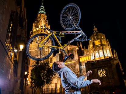 Christian López, con 95 récords Guiness, sostiene una bicicleta con su barbilla en la plaza del Ayuntamiento de Toledo.