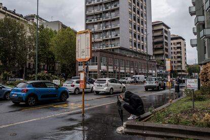 Un hombre, sentado en una calle de Sesto San Giovanni.