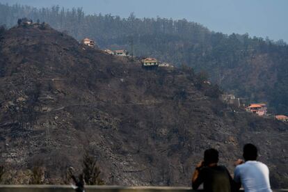 Los graves incendios que recorren Portugal en los últimos días han obligado al país a solicitar la activación del Mecanismo de Protección Civil —un programa europeo de respuesta inmediata a catástrofes—, según confirmó la ministra portuguesa de Interior, Constança Urbano de Sousa. En la foto, dos personas observando una colina devastada por el fuego en Babosas, isla de Madeira.