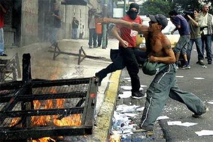 Un manifestante lanza piedras durante una protesta en el 30º aniversario del golpe, ayer en Buenos Aires.