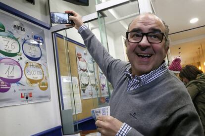 El administrador de lotería Óscar de Toro, se hace un selfie con el número agraciado con el segundo premio de la Lotería de Navidad, 4.536, vendido en su administración situada en un bar, esta mañana en Santiago de Compostela.