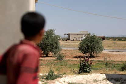 Un niño mira la casa donde se cree que tuvo lugar la detención de un líder del Estado Islámico durante una operación de la coalición internacional contra ese grupo yihadista este jueves, en la aldea de Al Humaira, en el norte de Siria,