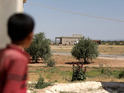 Un niño mira la casa donde se cree que tuvo lugar la detención de un líder del Estado Islámico durante una operación de la coalición internacional contra ese grupo yihadista este jueves, en la aldea de Al Humaira, en el norte de Siria,