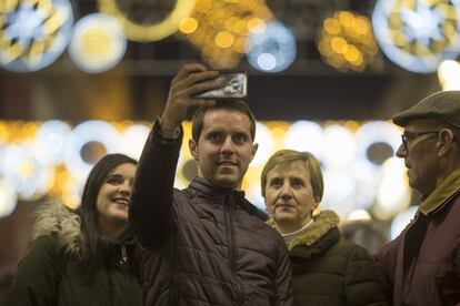 Varias personas se fotografían ante el alumbrado navideño en Sevilla.