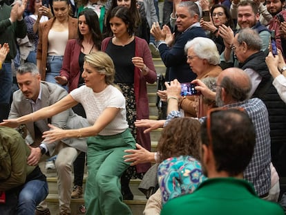 Yolanda Díaz (centro) ayuda a un hombre que pierde el equilibrio, este domingo en Sevilla.