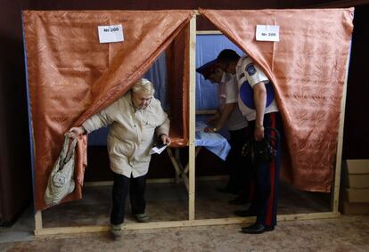 Dois servidores públicos da defesa civil votam em um colégio eleitoral em Slaviansk.