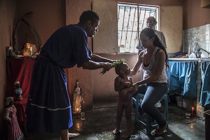 Un niño es tratado por un curandero de su infección estomacal. Muchos venezolanos han recurrido a métodos alternativos a la ciencia en estos últimos años. El conocido como callejón de los brujos, en la entrada de la favela de Petare, en Caracas, acoge cada día a decenas de enfermos que buscan en los curanderos un alivio para las dolencias que no pudieron atender en el desplomado sistema de salud del país. 