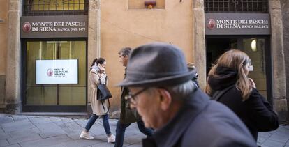 Viandantes, ante una oficina del banco Monte dei Paschi de Siena.