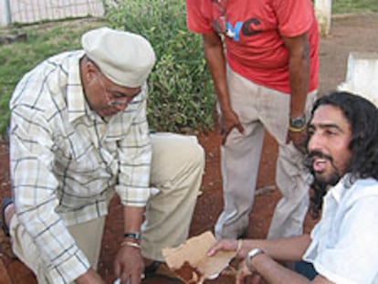 Chucho Valdés, a la izquierda, y El Cigala recogen tierra para Bebo Valdés.