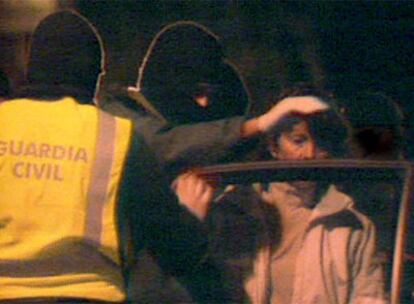 Agentes de la Guardia Civil introducen en un coche a una de las empresarias detenida en Usurbil.