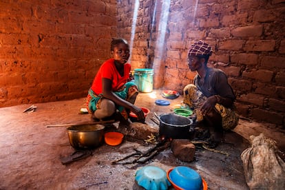 Joanita y su madre, Casilda, preparan un fuego en una de las estancias de la casa, que no tiene cocina. Aquí hacen la mandioca molida cocida, base de su alimentación.