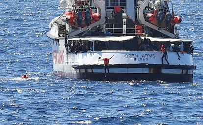 Varias personas saltan del barco de rescate 'Open Arms' cerca de la costa de Lampedusa, Italia. El buque se encuentra fondeado a menos de 800 metros de la isla, pero el bloqueo impuesto por el ministro de Interior italiano, Matteo Salvini, le impide atracar en puerto.