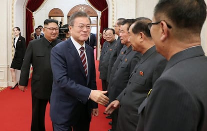 El presidente surcoreano Moon Jae-in estrecha la mano de funcionarios norcoreanos.