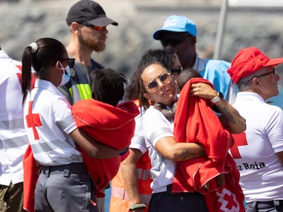 Efectivos de emergencias atienden a inmigrantes, entre ellos varios menores, llegados a Arguineguín al puerto de Arguineguín, en Gran Canaria, este agosto.