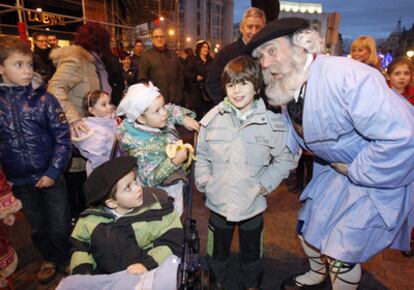 El Olentzero saluda a varios niños en las inmediaciones de la plaza Moyúa de Bilbao.