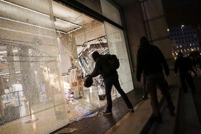 Protesters smash a shop window in Barcelona.