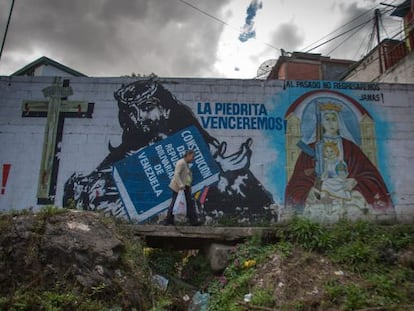 Un hombre camina frente a una pared con mensajes de apoyo al presidente Hugo Ch&aacute;vez.