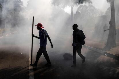 Los partidarios de la oposición zimbabuense MDC, caminan entre el humo después de que la policía disparase gases lacrimógenos durante los enfrentamientos en Harare. 