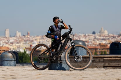 Un ciclista se hidrata este martes en el Parque Lineal del Manzanares en Madrid, en una nueva jornada de calor.