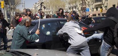 Violentos pateando un coche en el paseo de Gr&agrave;cia de Barcelona la tarde del 29 de marzo. 
