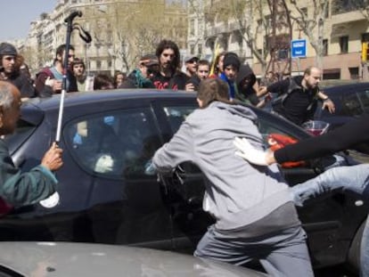 Violentos pateando un coche en el paseo de Gr&agrave;cia de Barcelona la tarde del 29 de marzo. 