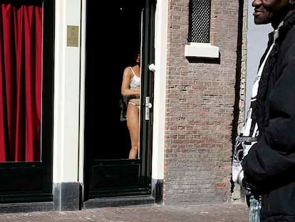 Una prostituta se exhibe ante los transeúntes en un burdel del <i>distrito rojo</i> de Ámsterdam.