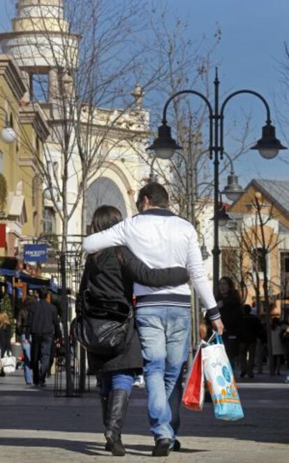 Una pareja en la entrada de centro comercial Las Rozas Village.