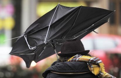 Una mujer se protege en Pamplona de la lluvia y el viento con su paraguas donde la capital navarra y el resto de la Comunidad foral se encuentra en alerta naranja por riesgo importante de nevadas.