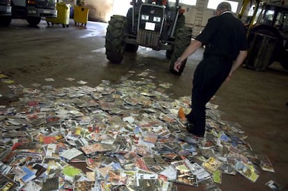 Agentes policías destruyen copias de discos compactos incautados.