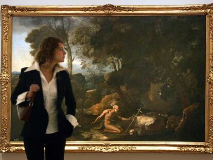 Una visitante de la exposición <i>Poussin y la naturaleza, </i>ante el cuadro <i>Paisaje con san Jerónimo.