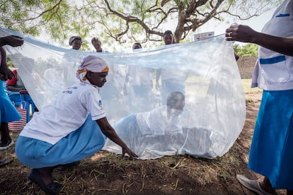 Reparto de mosquiteras para protegerse de la malaria en una comunidad rural de Kenia.