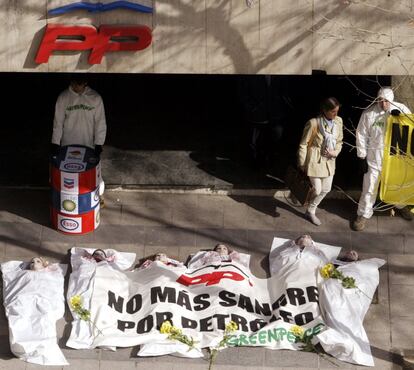 Varios activistas escenifican los efectos de un bombardeo en la guerra de Irak en las puertas de la sede del PP, en febrero de 2003.
