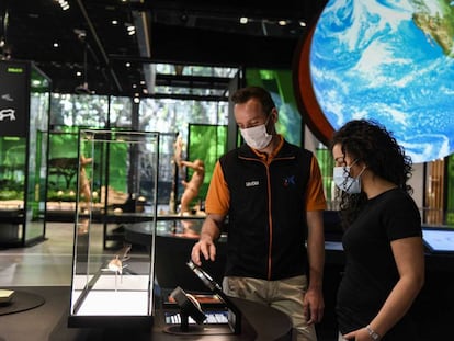 Dues persones interactuen amb una de les exposicions del CosmoCaixa, a Barcelona.