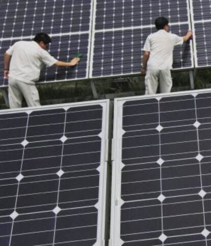 Un grupo de trabajadores chinos limpia unos paneles solares en Hebei, China.