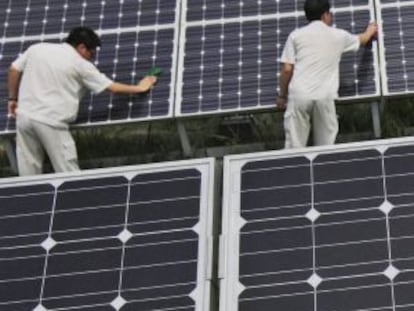 Un grupo de trabajadores chinos limpia unos paneles solares en Hebei, China.
