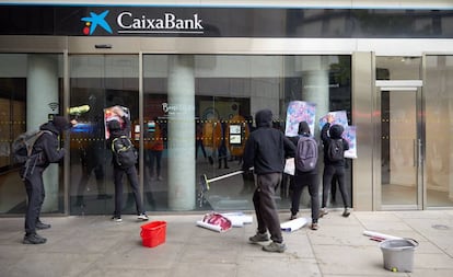 Piquetes de huelga pegan carteles a primera hora de este viernes en una sucursal de La Caixa en Girona.