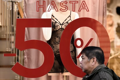Un escaparate anuncia rebajas de hasta el 50% en una tienda del centro de Madrid, este domingo. 