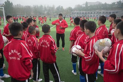 China solamente ha participado en un Mundial, en 2002, en el que perdió todos los partidos disputados. En la imagen, varios niños escuchan las instrucciones del entrenador en la escuela de artes marciales de Tagou, Dengfeng (China).