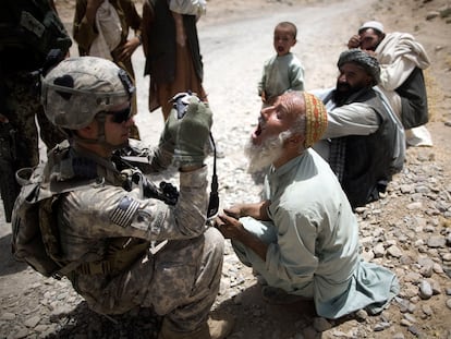 El soldado Brad Parrish, de la 101 División Aerotransportada, toma una fotografía de la dentadura de un campesino afgano, para su identificación.