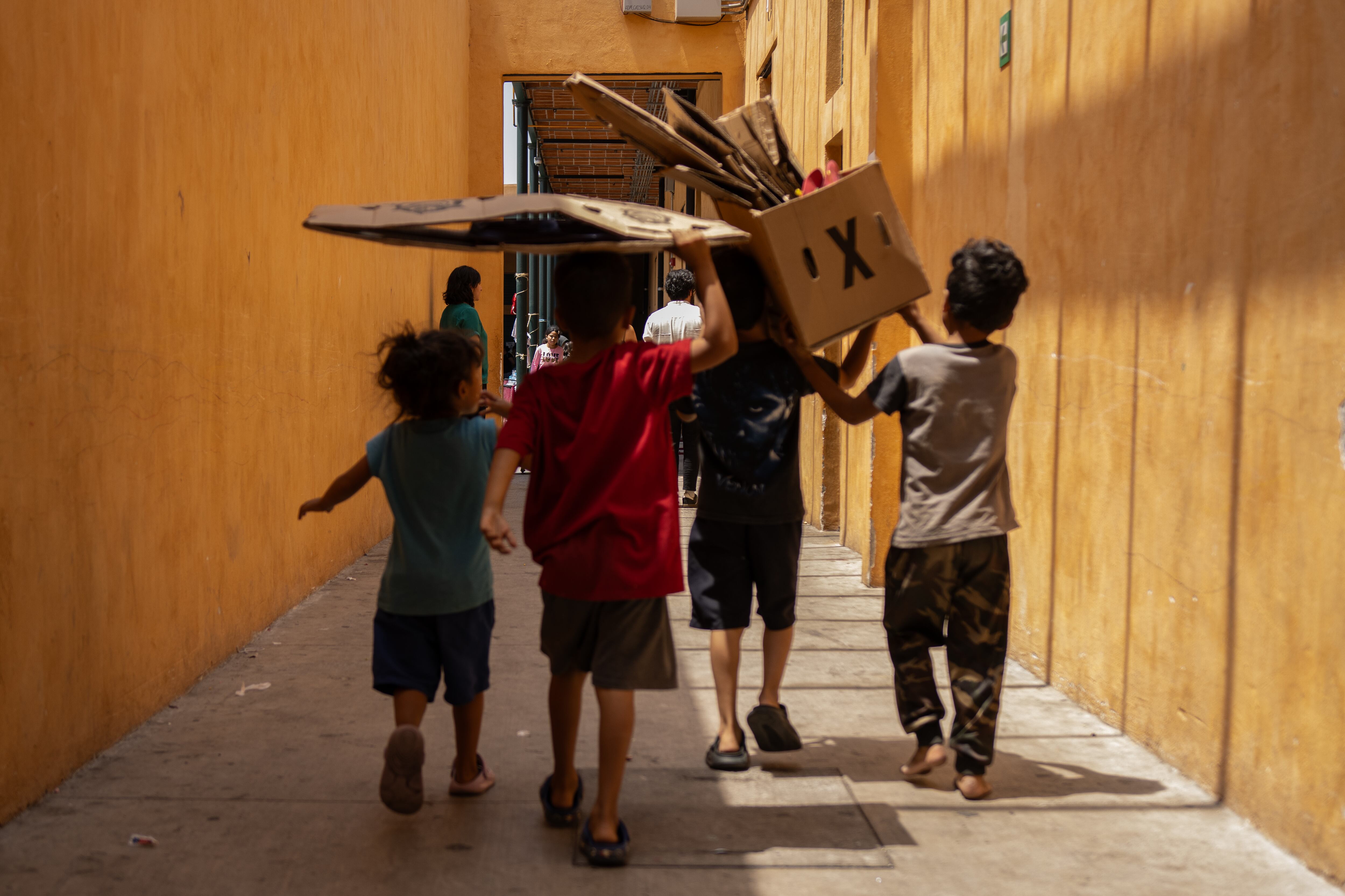 Niños y niñas que juegan en los pasillos del Centro de Asistencia e Integración Social Vasco de Quiroga, donde se albergan decenas de migrantes.